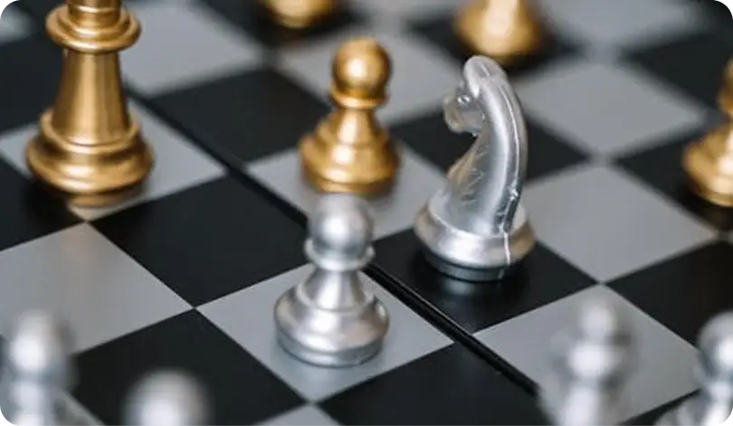 Close-up van schaakstukken, waaronder een paard en pionnen op een schaakbord, ter illustratie van strategie, planning en tactische besluitvorming in een klassiek spel